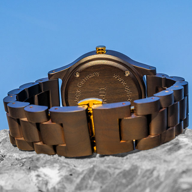 Opis UR-U1: Il classico orologio da polso unisex in legno, stile retrò - realizzato in sandalo nero con l’esclusivo quadrante goffrato in verde e parti metalliche in oro