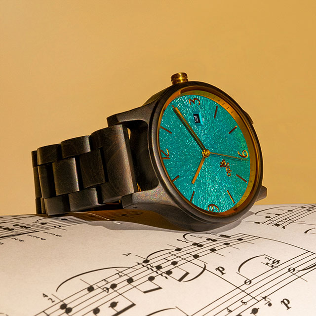 Opis UR-U1: el clásico reloj retro unisex hecho de sándalo negro con una esfera en relieve en turquesa y partes metálicas dorados